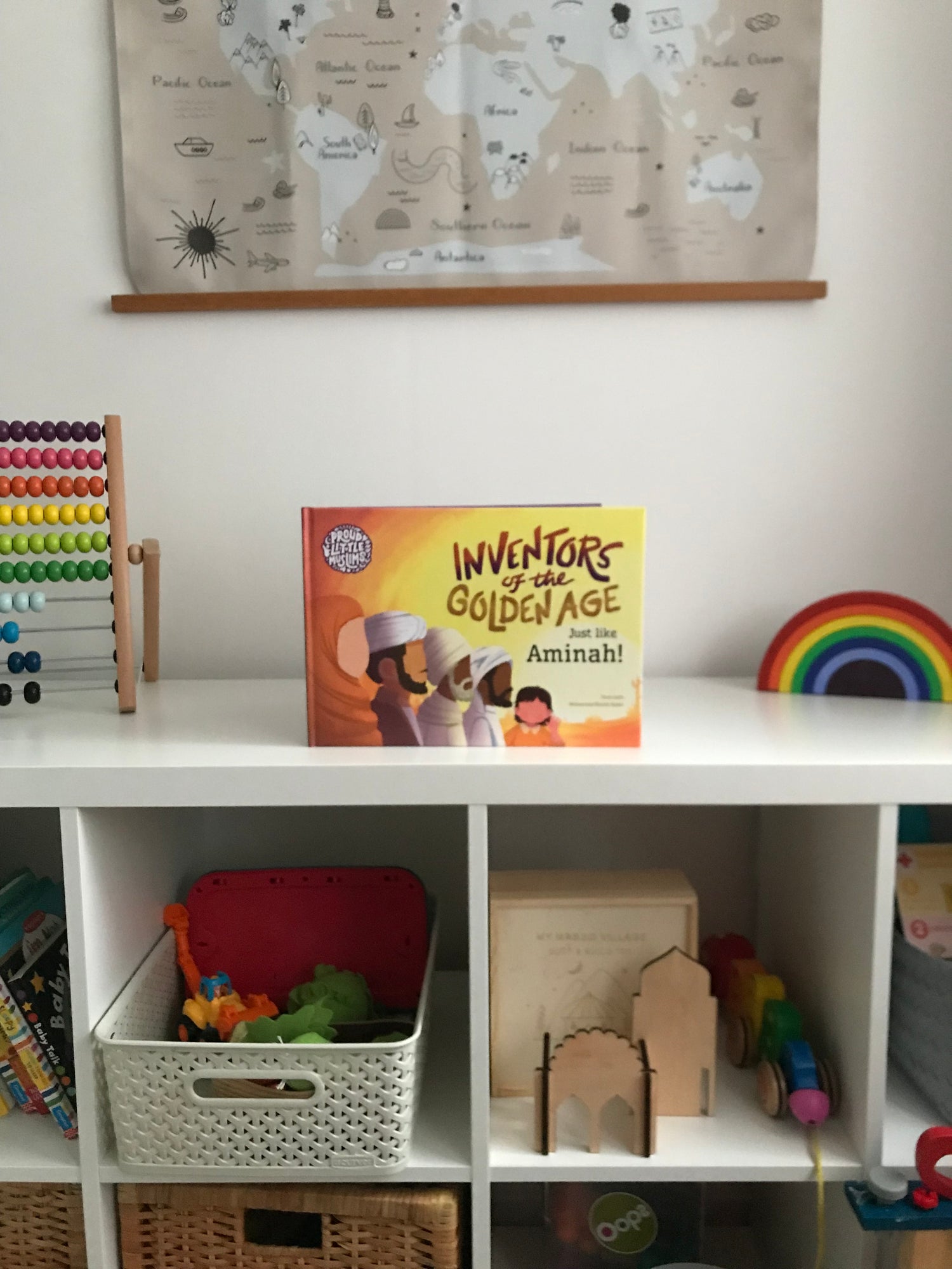A Personalised Muslim Children's book by Proud Little Muslims on a bookshelf of colourful toys. The story is about the Islamic Golden Age called Inventors of the Golden Age: Just like you!